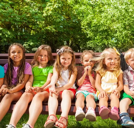 kids row bench summer park front group portrait group sitting boys girls years old 43981118.jpg e1777501673682.webp
